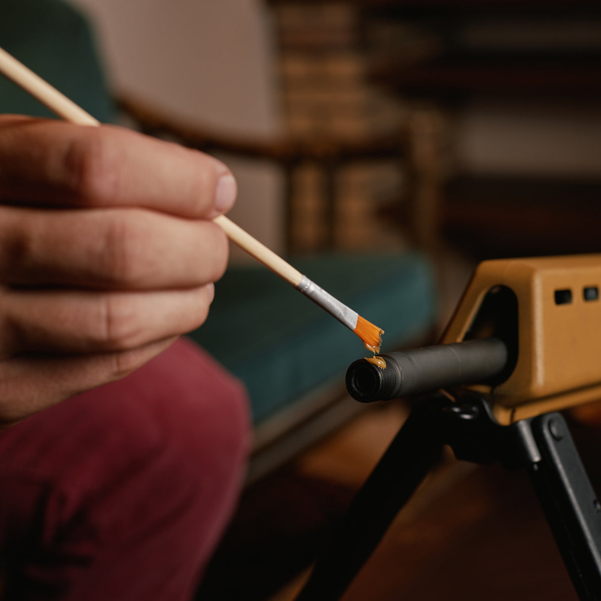 Waffenfett wird vorsichtig auf Gewehrlauf gepinselt